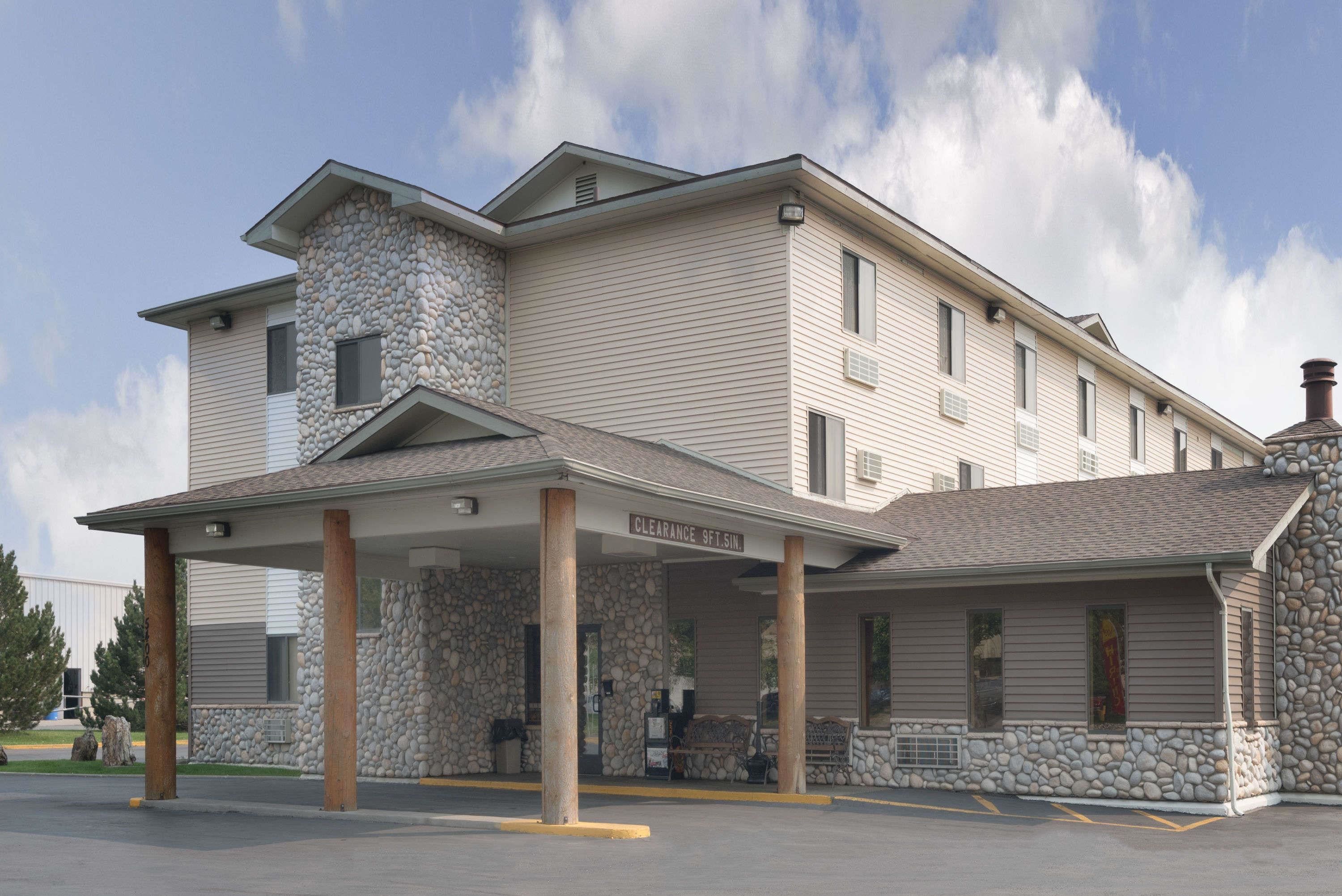 A two-story building with a stone facade and a covered entrance area.
