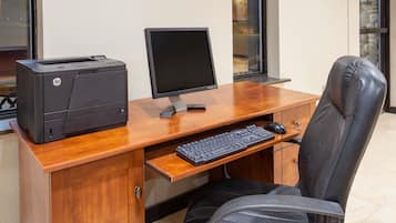A wooden desk with an HP printer, a monitor, and a keyboard.