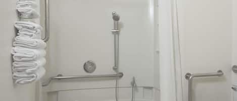 A bathroom with a bathtub, a toilet, and a shower area.