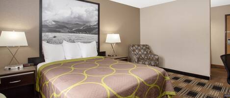 A hotel room with a large bed, two bedside tables with lamps, a chair, and a large framed picture on the wall.