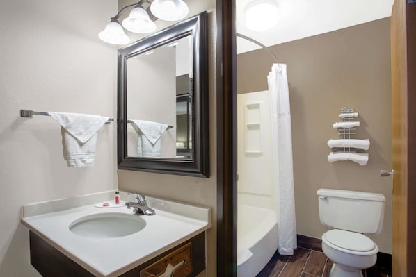Un baño con lavamanos, espejo e inodoro.