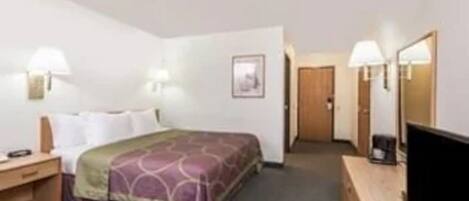 A hotel room with a bed, bedside tables, a TV, and a door leading to another room.