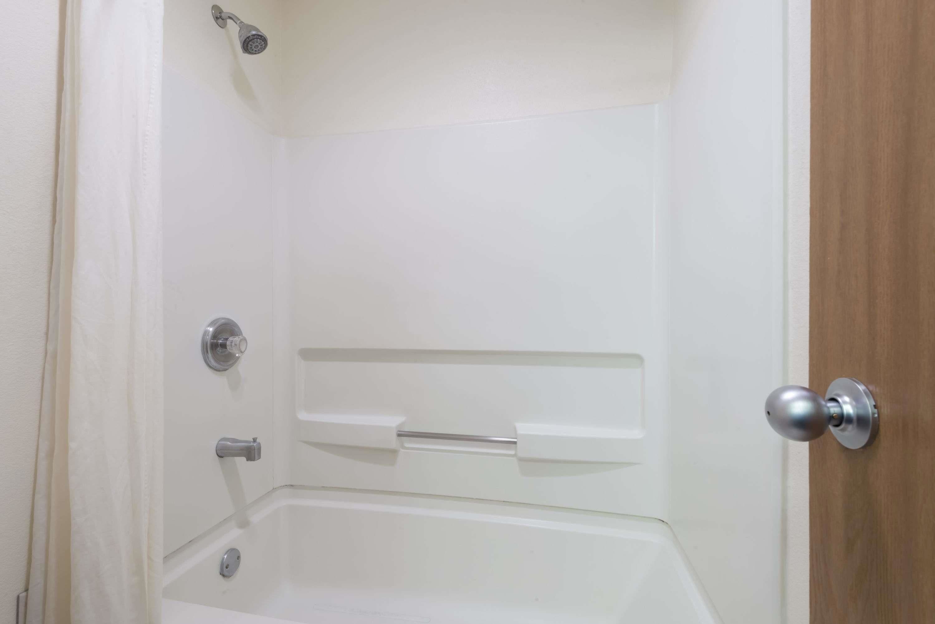 A bathroom with a shower, a toilet, and a sink.