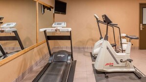 A gym with a treadmill, elliptical, and a stationary bike.