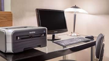 A desk with a Brother printer, a Samsung monitor, a keyboard, a mouse, and a lamp.