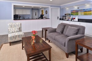 Relax in this stylish living area with a sofa, armchair, and coffee table, offering a comfortable space to unwind.