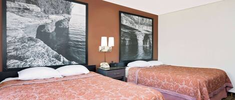 A hotel room with two beds, a nightstand, a telephone, and two wall-mounted lamps.