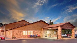 Ein Motel mit Backsteinfassade, einer überdachten Eingangspartei und einer Reihe von Stühlen vor der Fassade.