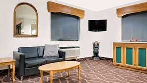 Ein Wohnzimmer mit einer Couch, einem Couchtisch, einem Fernseher und einem Schrank.