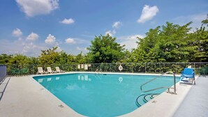 A swimming pool with a metal ladder, surrounded by a metal fence. There are lounge chairs along the poolside. - Super 8 by Wyndham Nashville/ Dntn/ Opryland Area (Nashville)