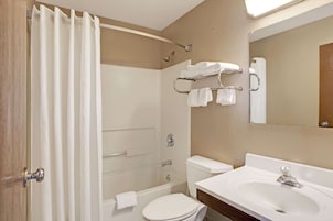 A bathroom with a bathtub, toilet, and sink.