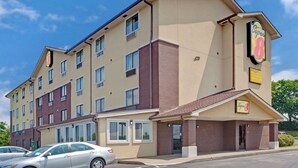A multi-story hotel with a beige and brown facade, multiple windows, and a prominent 'Super 8' sign. - Super 8 by Wyndham Nashville/ Dntn/ Opryland Area (Nashville)