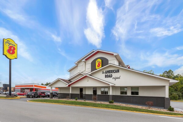 A Super 8 motel with a 'The American Road original' sign, a parking lot, and a clear blue sky. - Super 8 by Wyndham Summersville/New River National Park (Summersville)