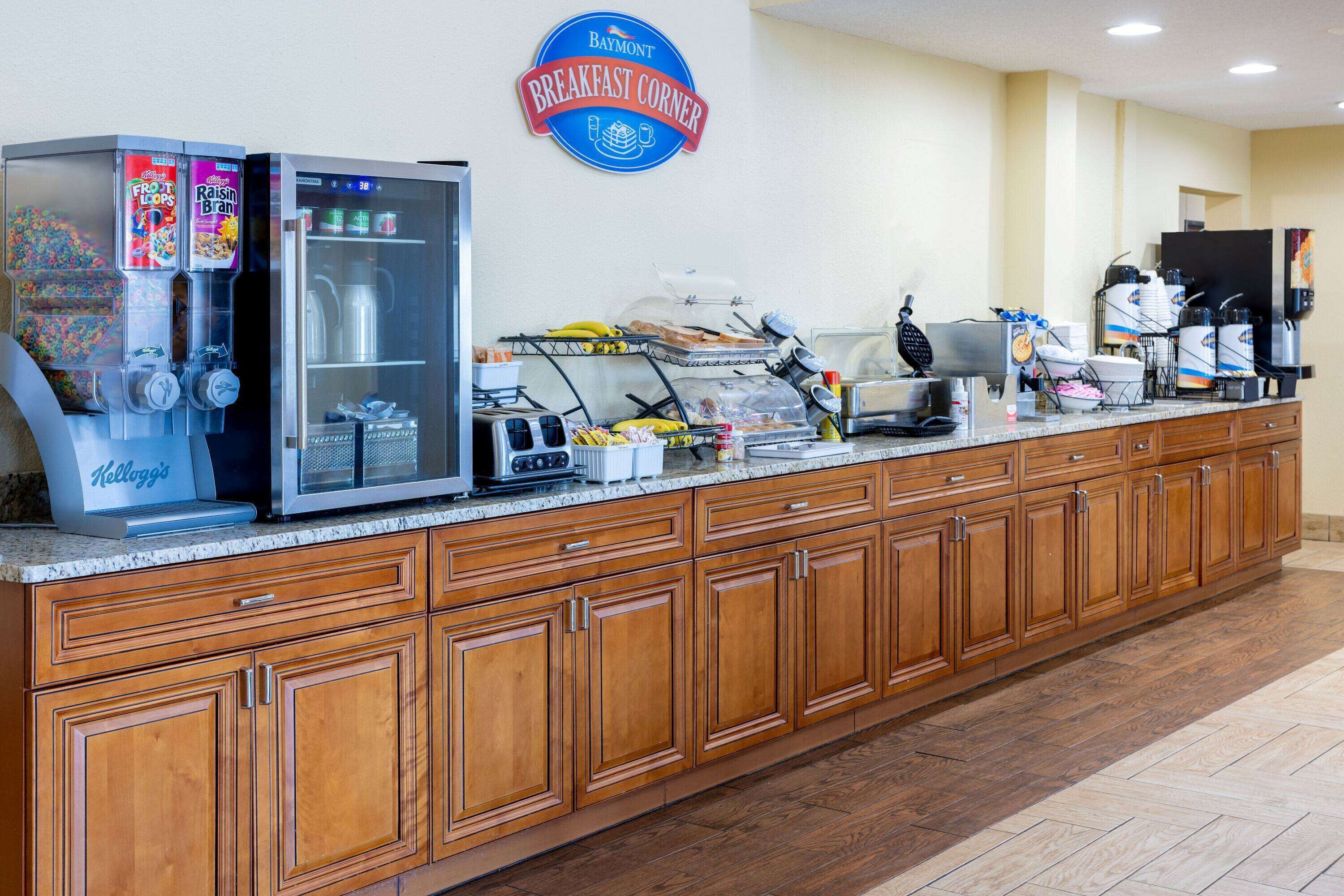 A breakfast bar with vending machines, a coffee station, and a sign reading "Breakfast Corner".