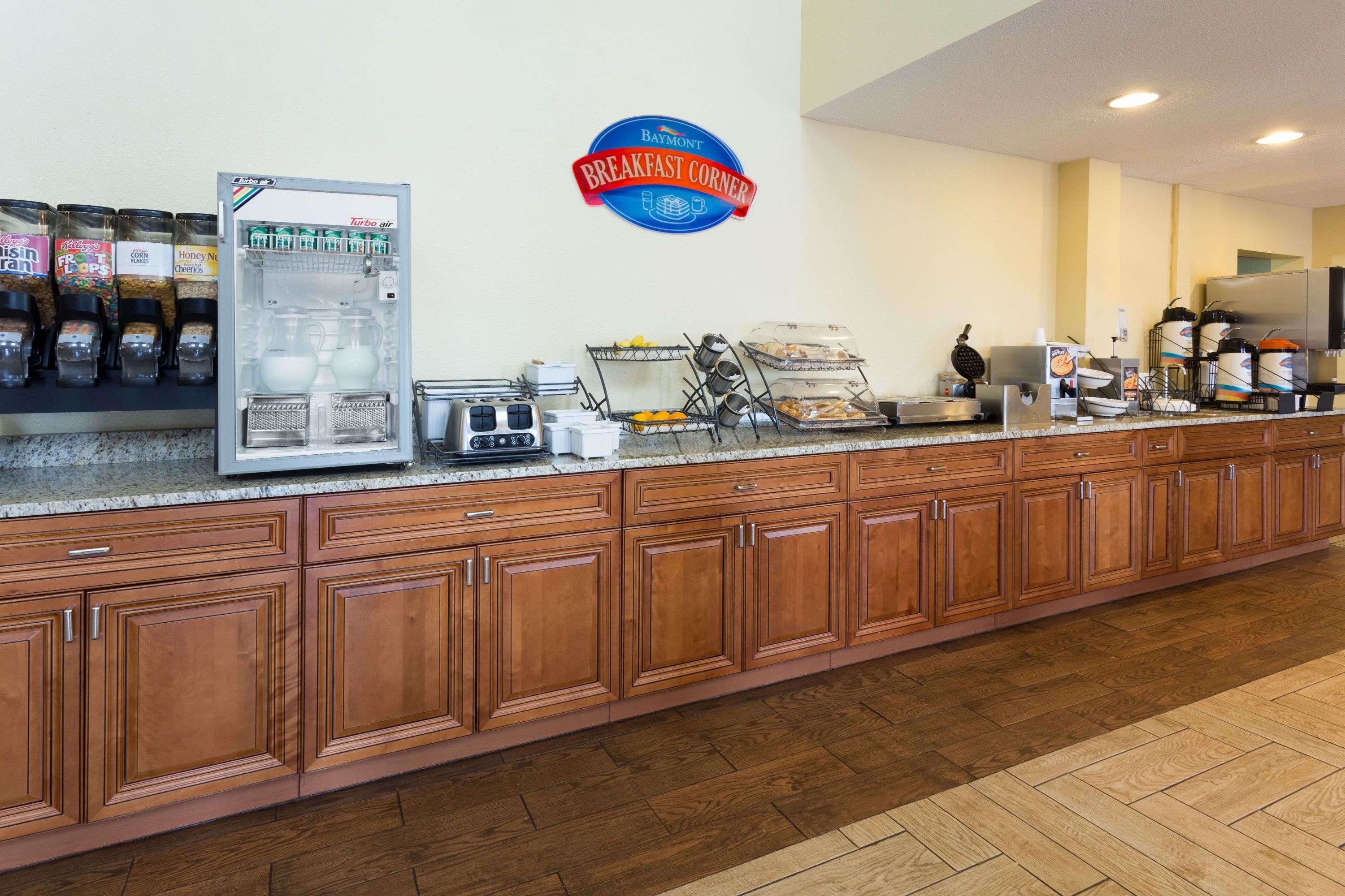 A breakfast bar with a coffee machine, a cereal dispenser, and a sign for the breakfast corner.