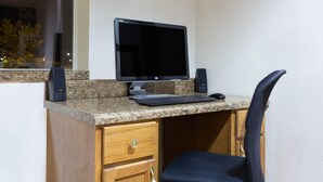 A workspace with a desktop computer, keyboard, mouse, and speakers on a granite countertop. - Super 8 by Wyndham Anderson/Clemson Area (Anderson)