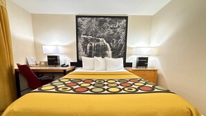 A hotel room with a bed, two bedside tables, a desk, a chair, and a large framed picture on the wall. - Super 8 by Wyndham Anderson/Clemson Area (Anderson)