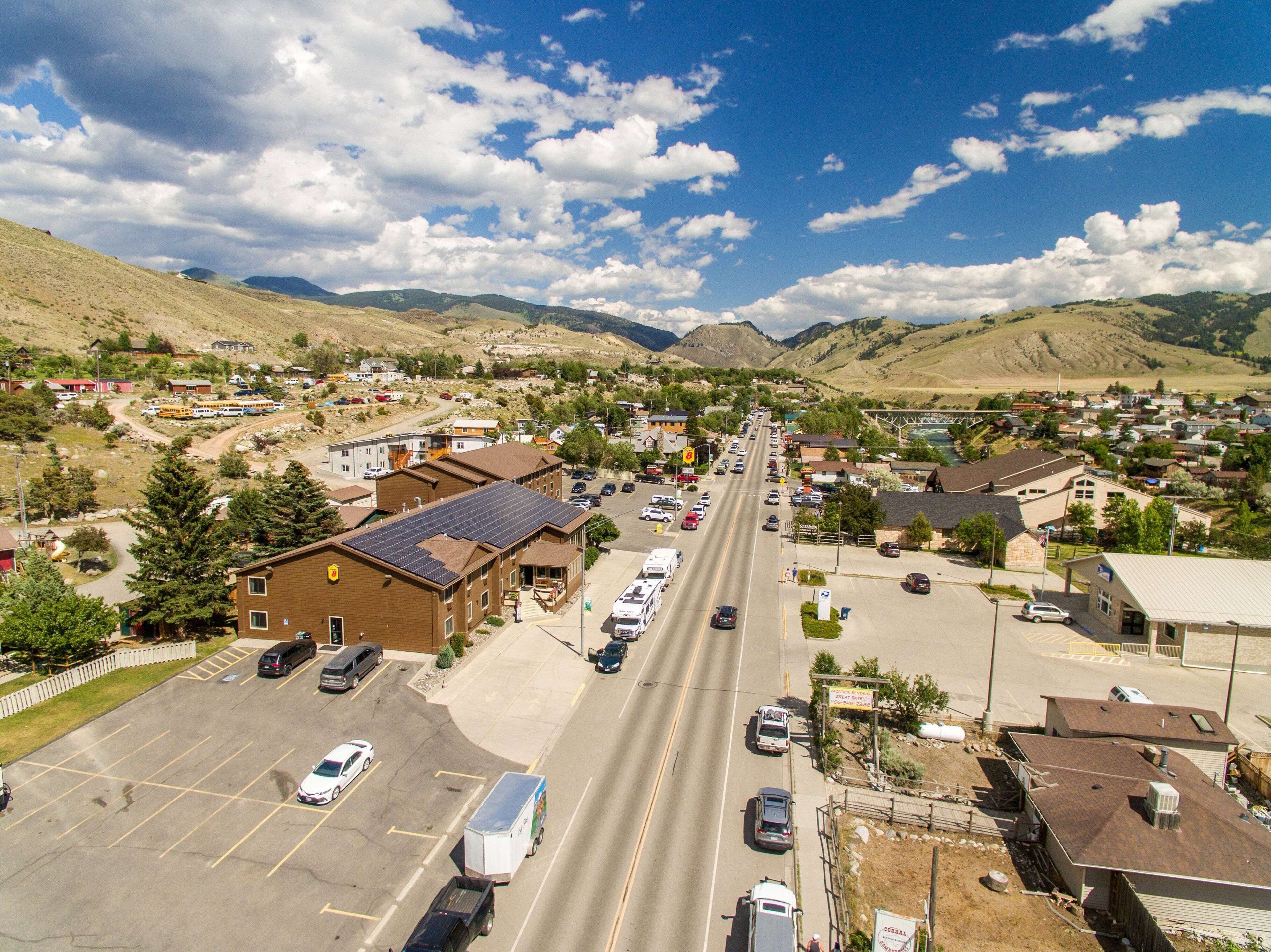 A town with a main road, buildings, and mountains in the background.