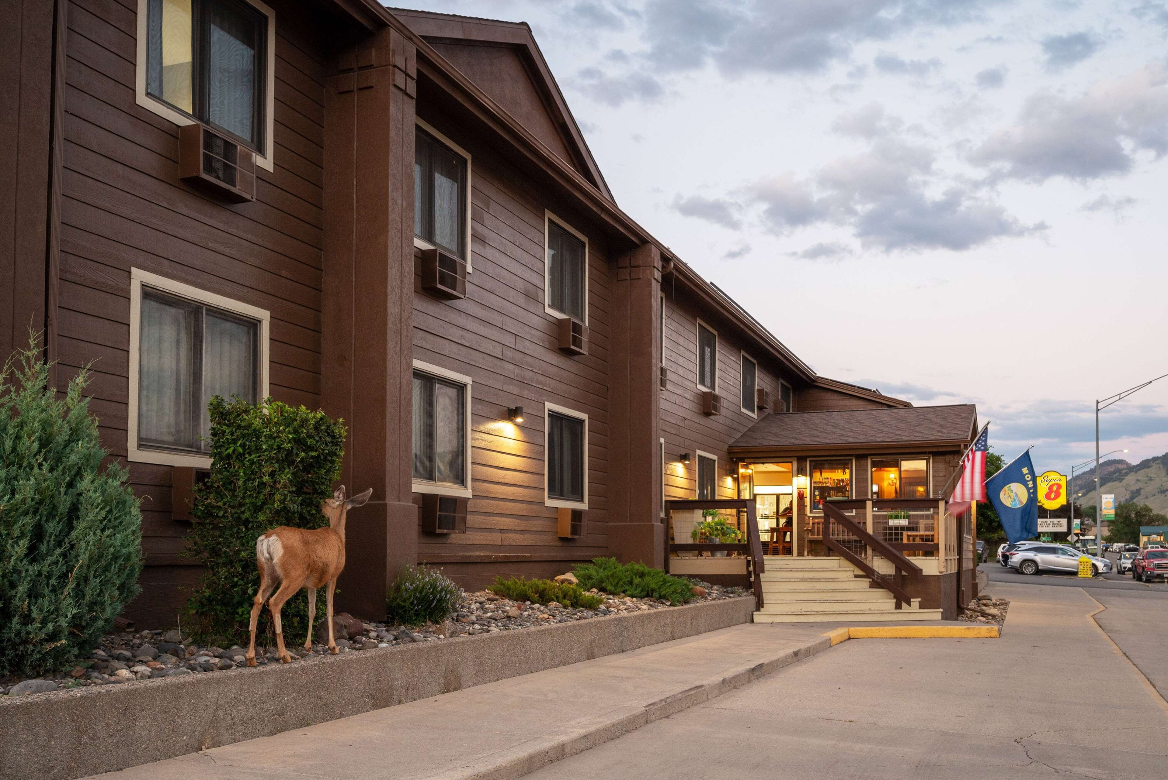 A two-story lodge with a wooden facade, a front entrance with steps, and a small American flag.
