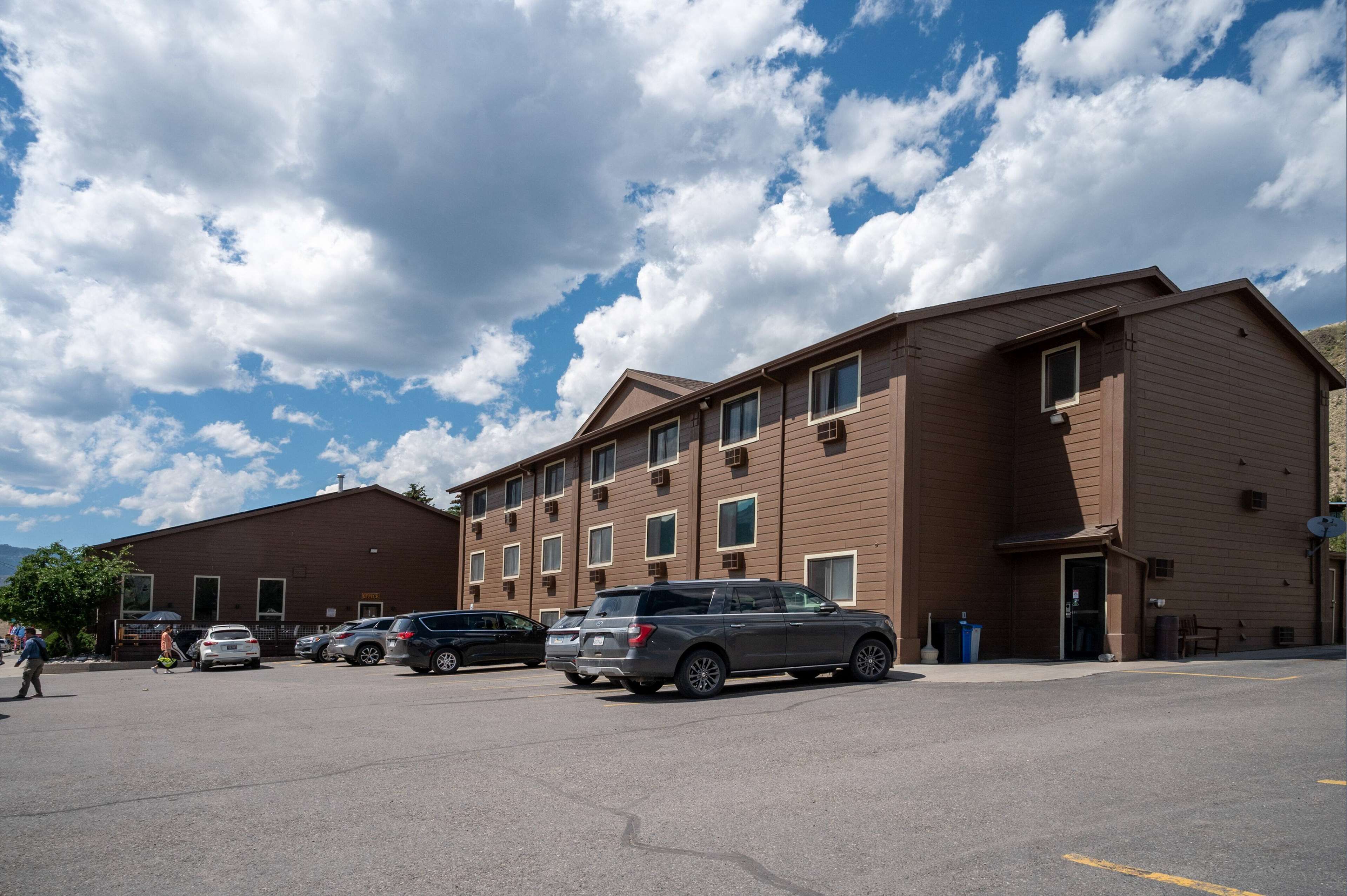 A multi-story building with a parking lot in front.