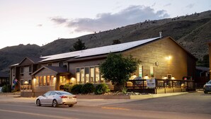 A building with a large windowed front, a solar panel roof, and a sign indicating a restaurant.