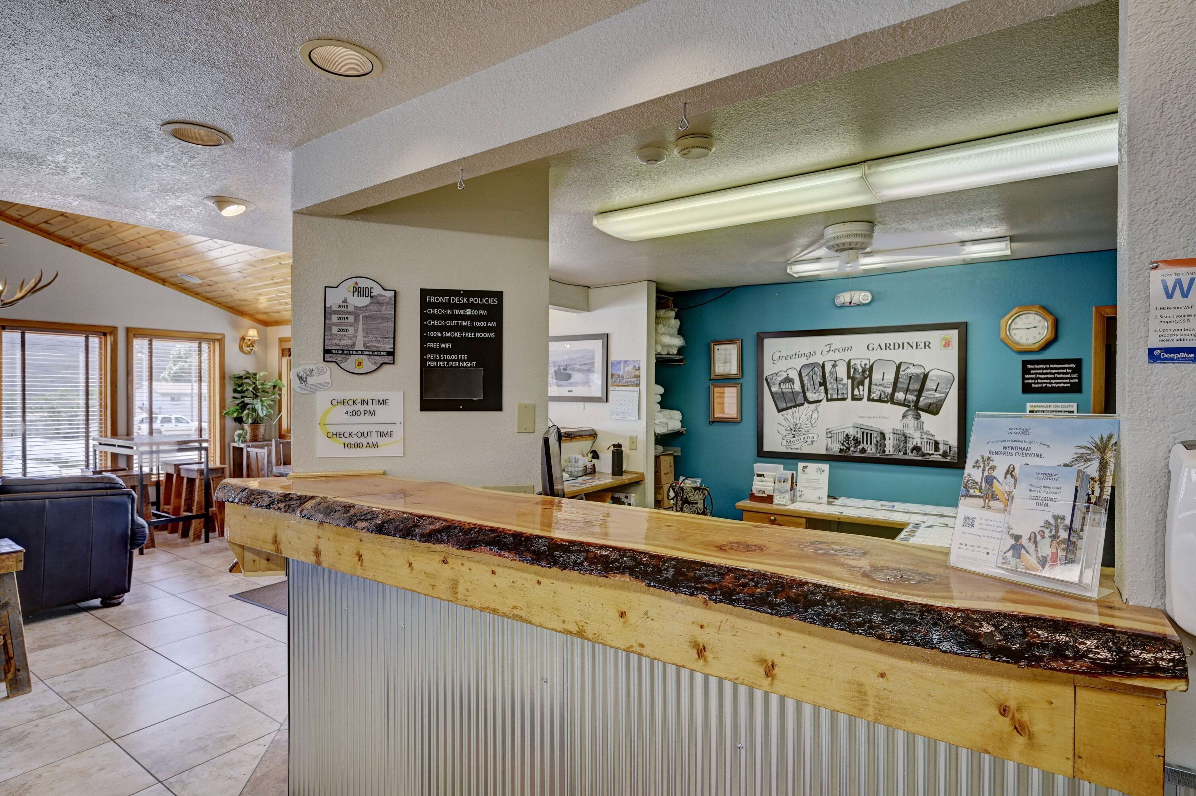 A reception area with a wooden counter, framed pictures, and a clock on the wall.