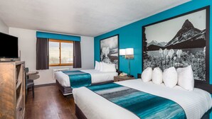 A hotel room with two beds, a TV, a desk, and a large window.
