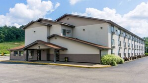 A multi-story hotel with a flat roof, a covered entrance, and a parking lot. - Super 8 by Wyndham Zanesville (Zanesville)