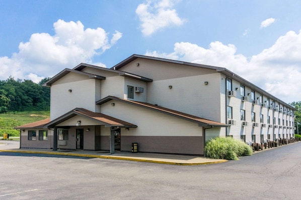 A multi-story hotel with a flat roof, a covered entrance, and a parking lot. - Super 8 by Wyndham Zanesville (Zanesville)