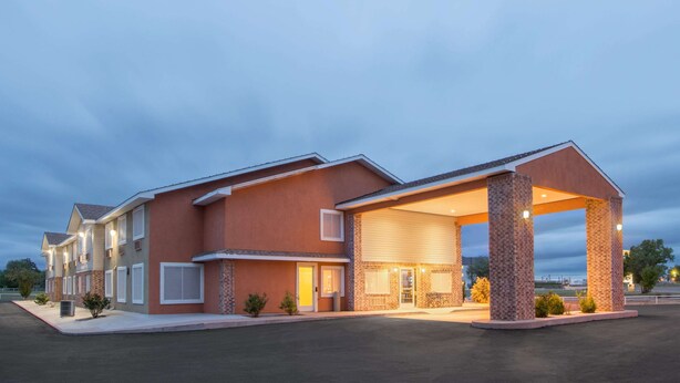 A multi-story hotel with a covered parking area and a brick facade. - Super 8 by Wyndham Portales (Portales)