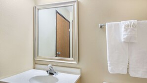 A bathroom with a white sink, a mirror, and a toilet. - Super 8 by Wyndham Portales (Portales)