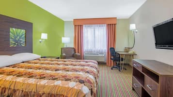 Quarto de hotel com uma cama grande, escrivaninha, cadeira, televisão e ar condicionado.