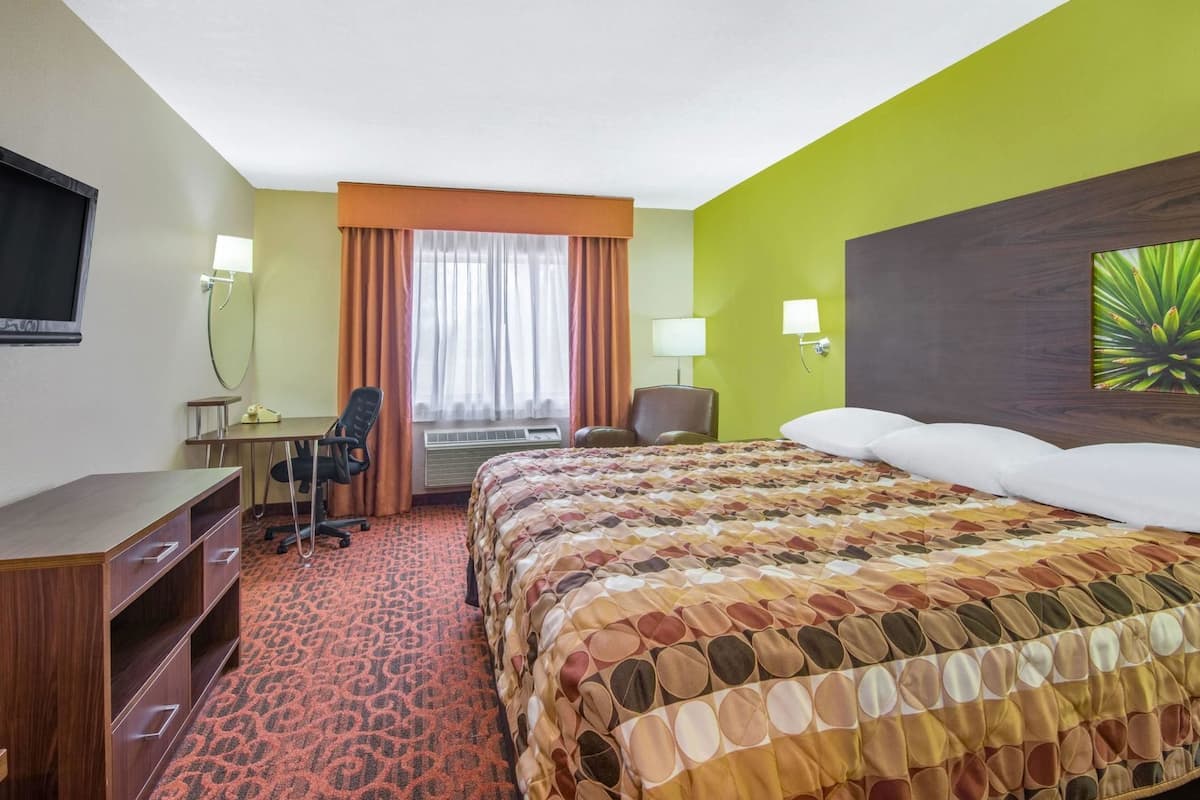 Une chambre d’hôtel équipée d’un lit, d’un bureau, d’une chaise et d’un téléviseur.
