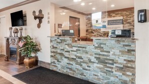 A reception area with a stone counter, a television, a fireplace, and an American flag.