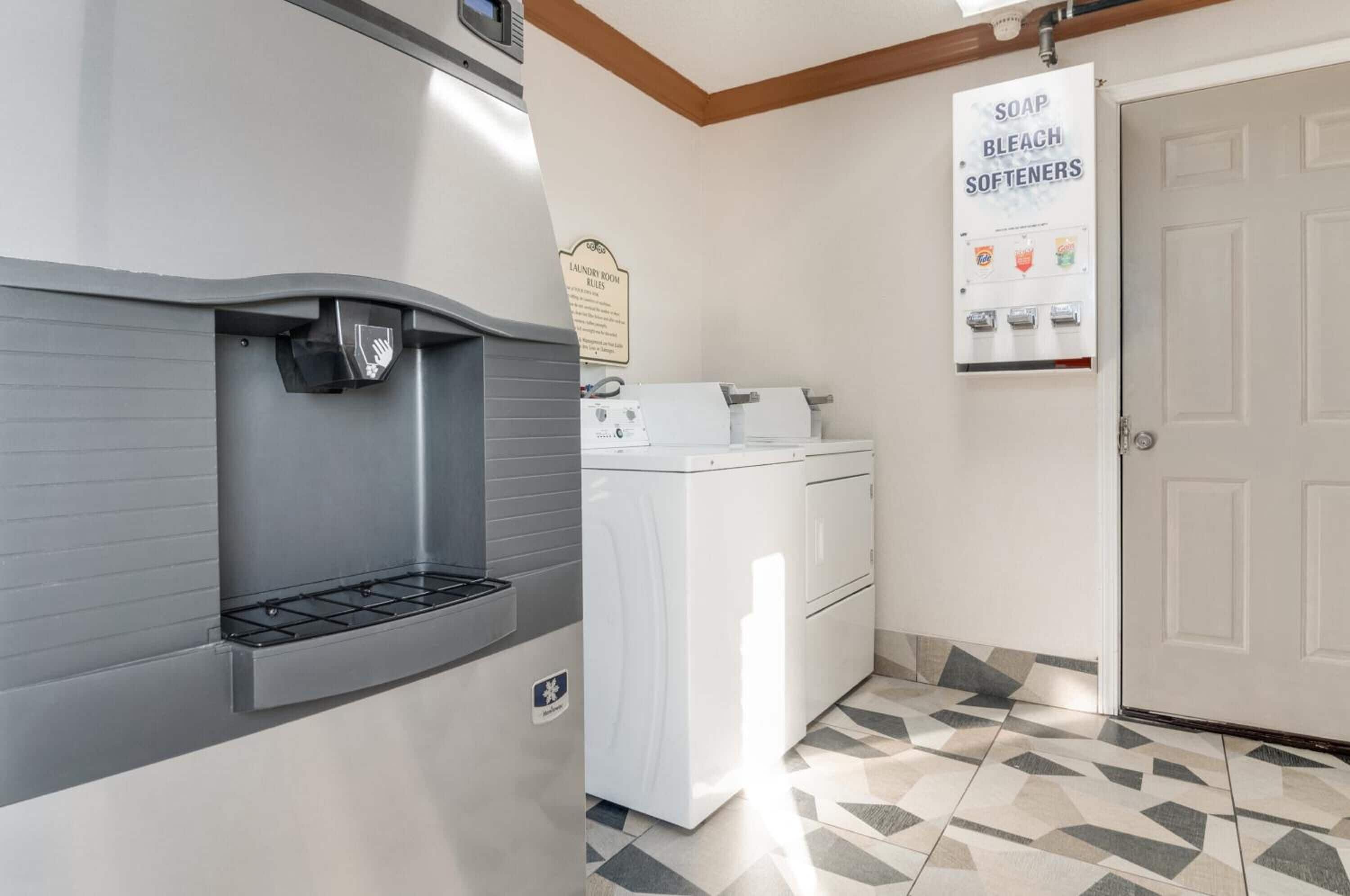 Een wasserette met een wasmachine, een droger en een doseringsautomaat voor wasmiddel, bleekmiddel en wasverzachter.