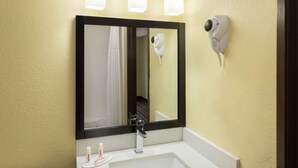 A bathroom with a white sink, a mirror, a hairdryer, and a towel rack. - Super 8 by Wyndham Marietta (Marietta)