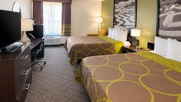 A hotel room with two beds, a desk with a television, and a window with curtains.