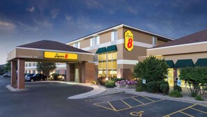 A Super 8 hotel with a clear entrance, parking lot, and handicap-accessible parking spaces. - Super 8 by Wyndham Madison South (Madison)
