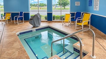 A pool area with a 3ft depth, tiled flooring, and chairs along the walls.