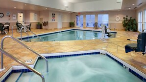 An indoor swimming pool with tiled flooring, metal handrails, and a lifeguard chair. - Super 8 by Wyndham Madison South (Madison)