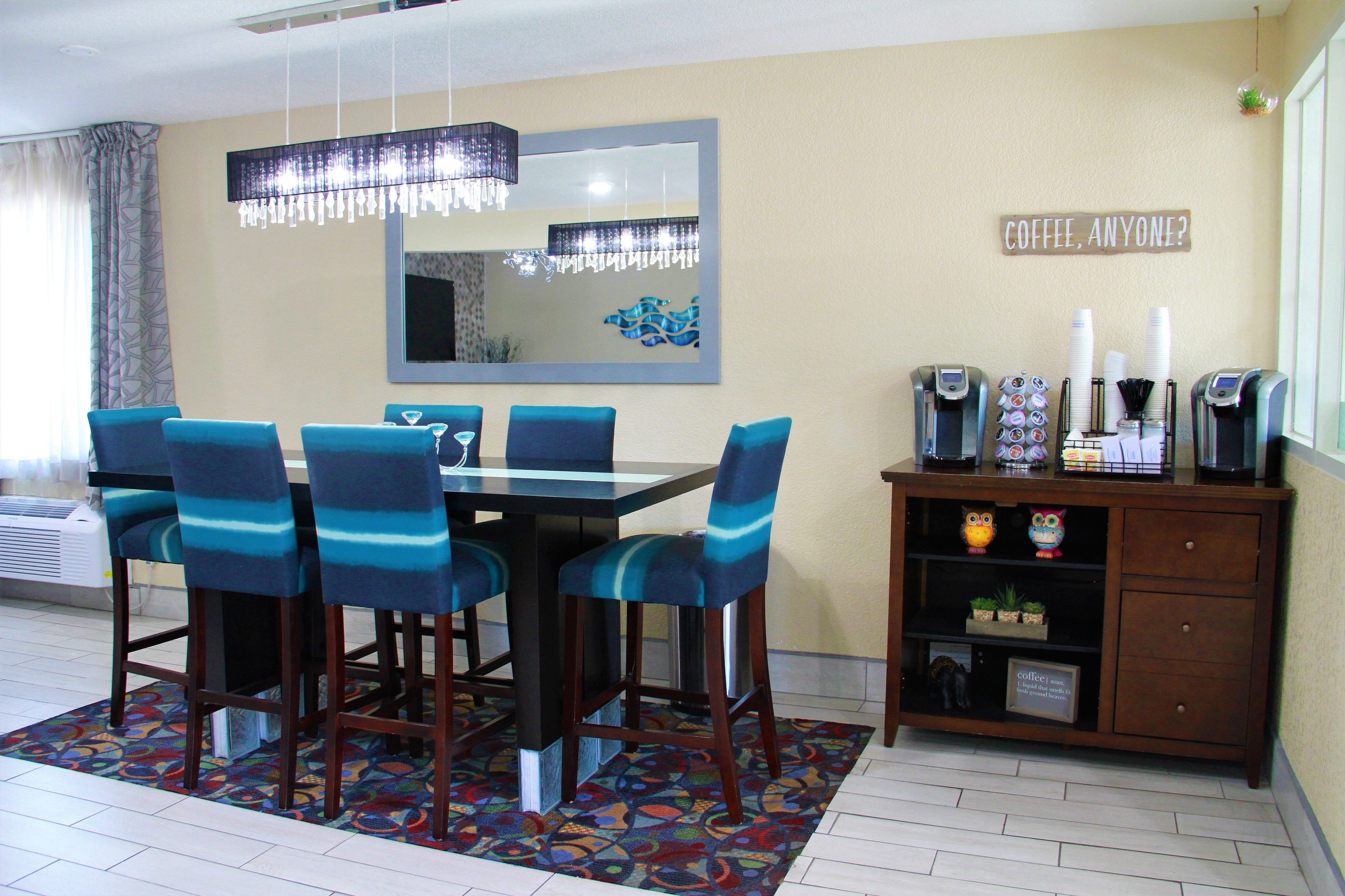 A dining area with a table, chairs, and a coffee station.