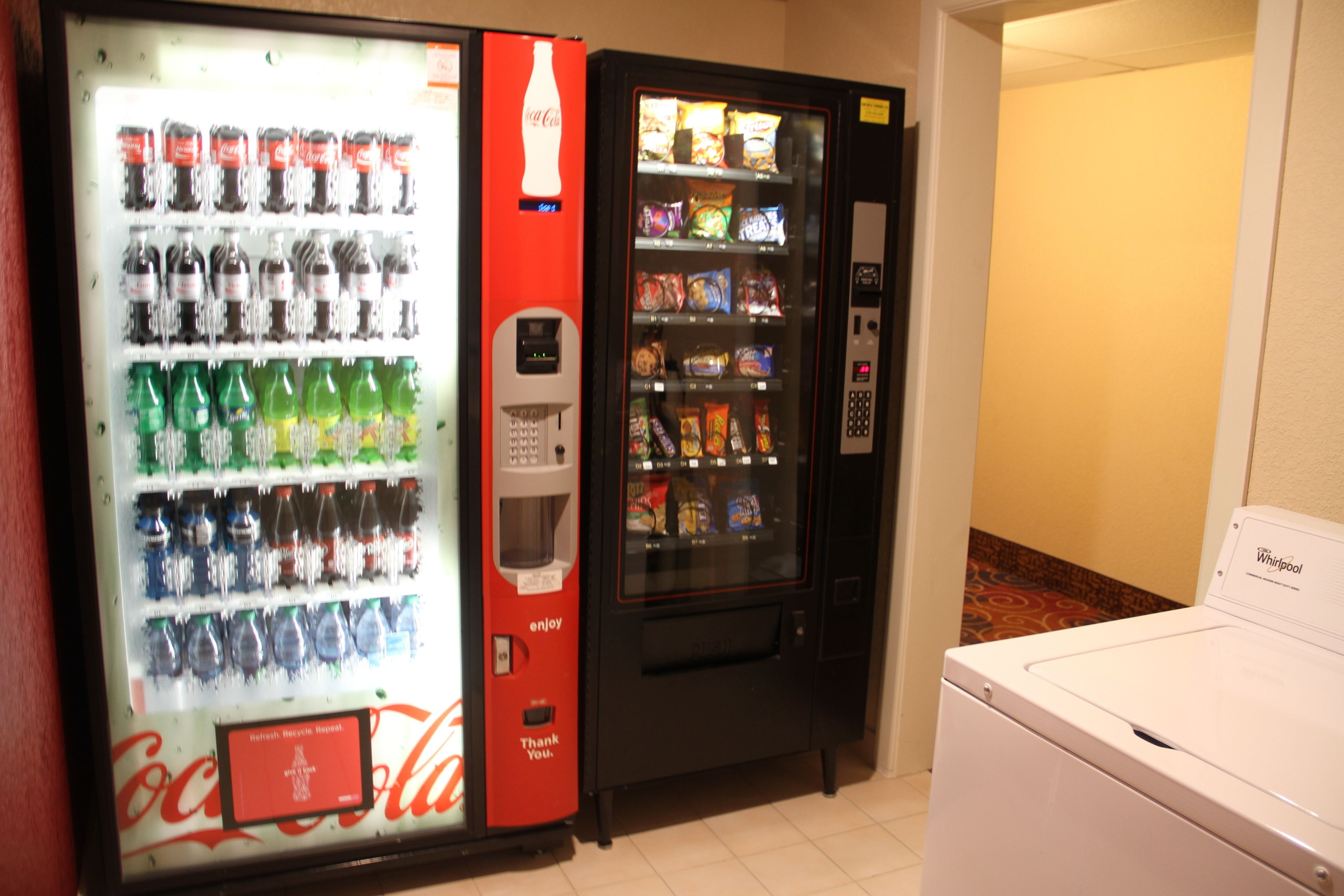 A vending machine with Coca-Cola and a Whirlpool appliance.