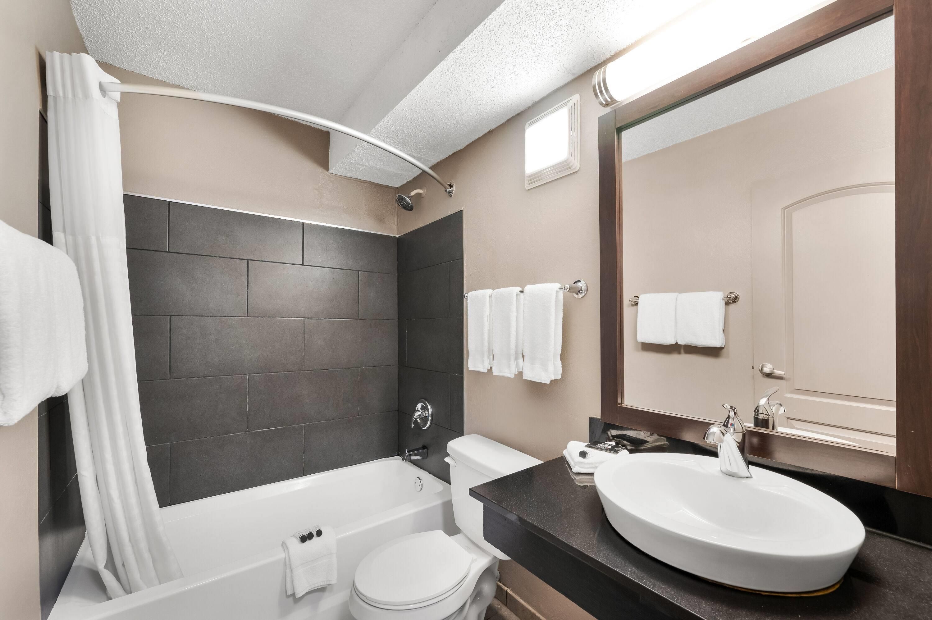 Un baño moderno con bañera, inodoro y lavamanos.