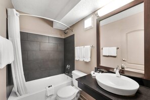 A modern bathroom with a bathtub, toilet, and sink. - Baymont by Wyndham Findlay (Findlay)