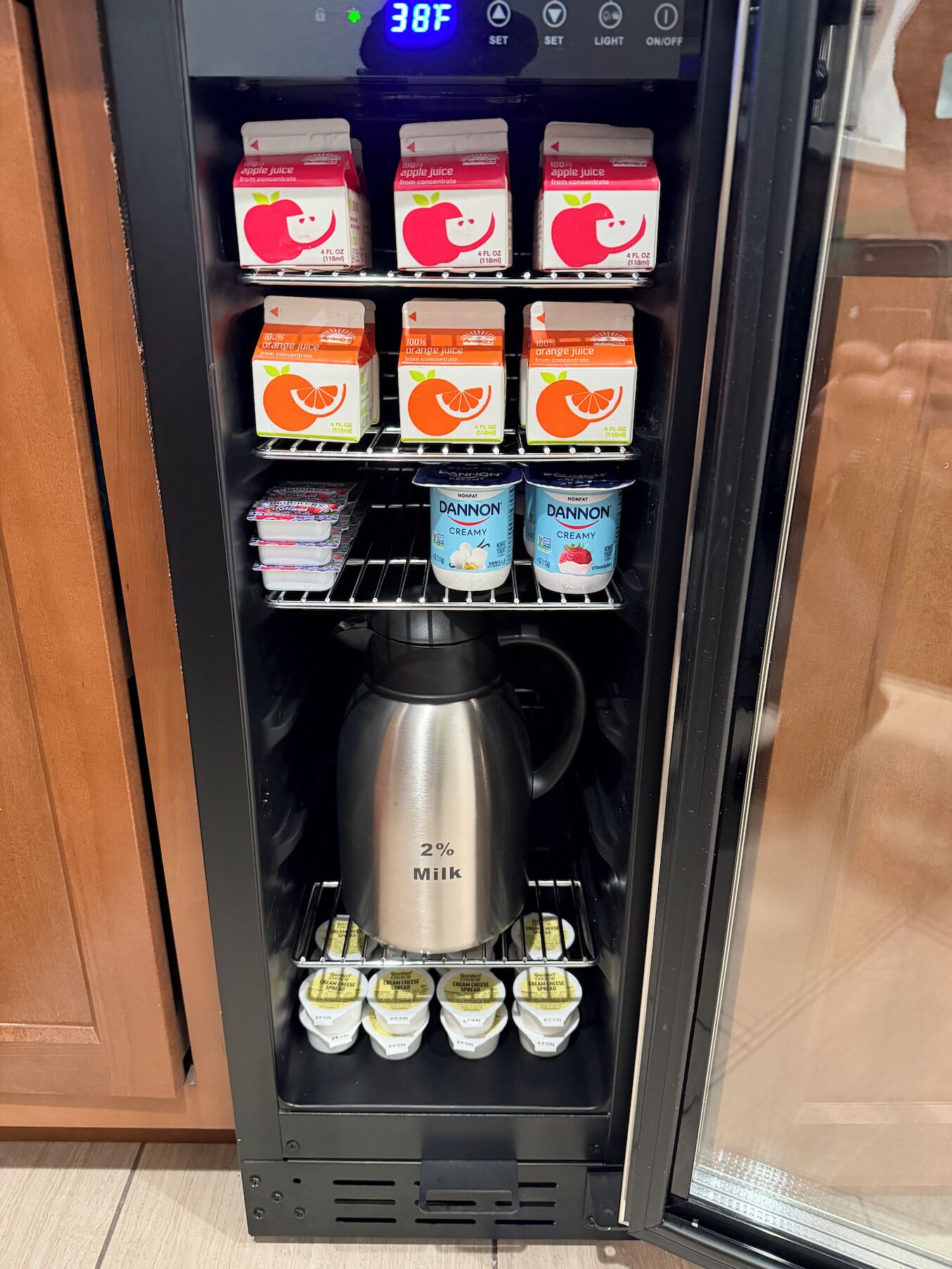 A beverage vending machine with apple and orange juice, Dannon nonfat yogurt, and a milk dispenser.