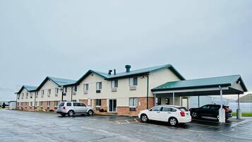 Connected buildings with a flat roof and covered parking area.