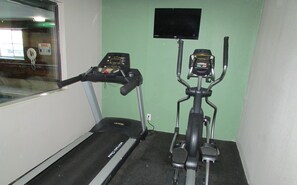 Two exercise bikes and a treadmill in a room with green walls. - Super 8 by Wyndham Rock Springs (Rock Springs)