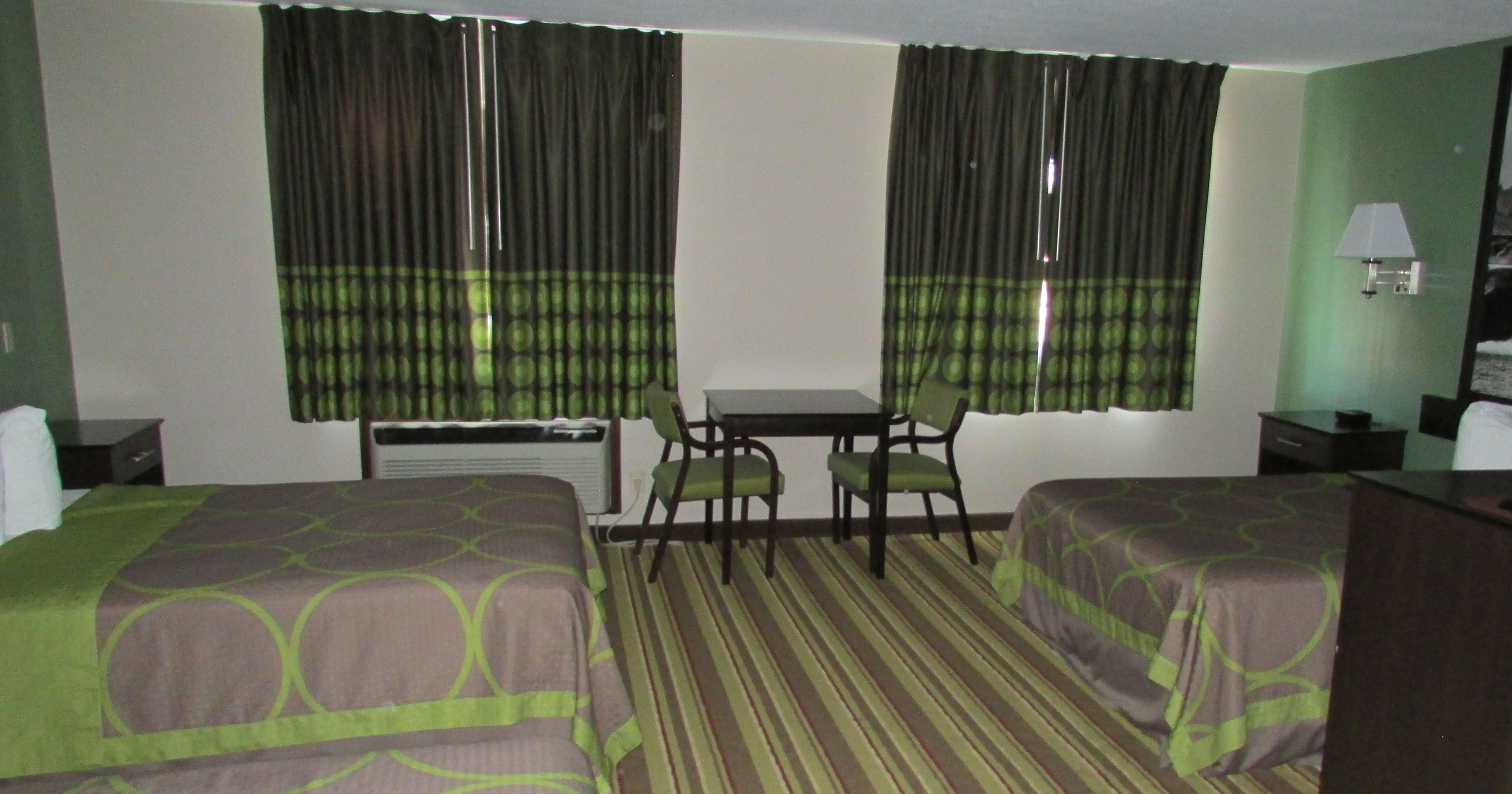Una habitación de hotel con dos camas, un escritorio y una silla.