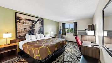 Una habitación de hotel con una cama grande, un escritorio, una silla, una lámpara y una ventana con cortinas.