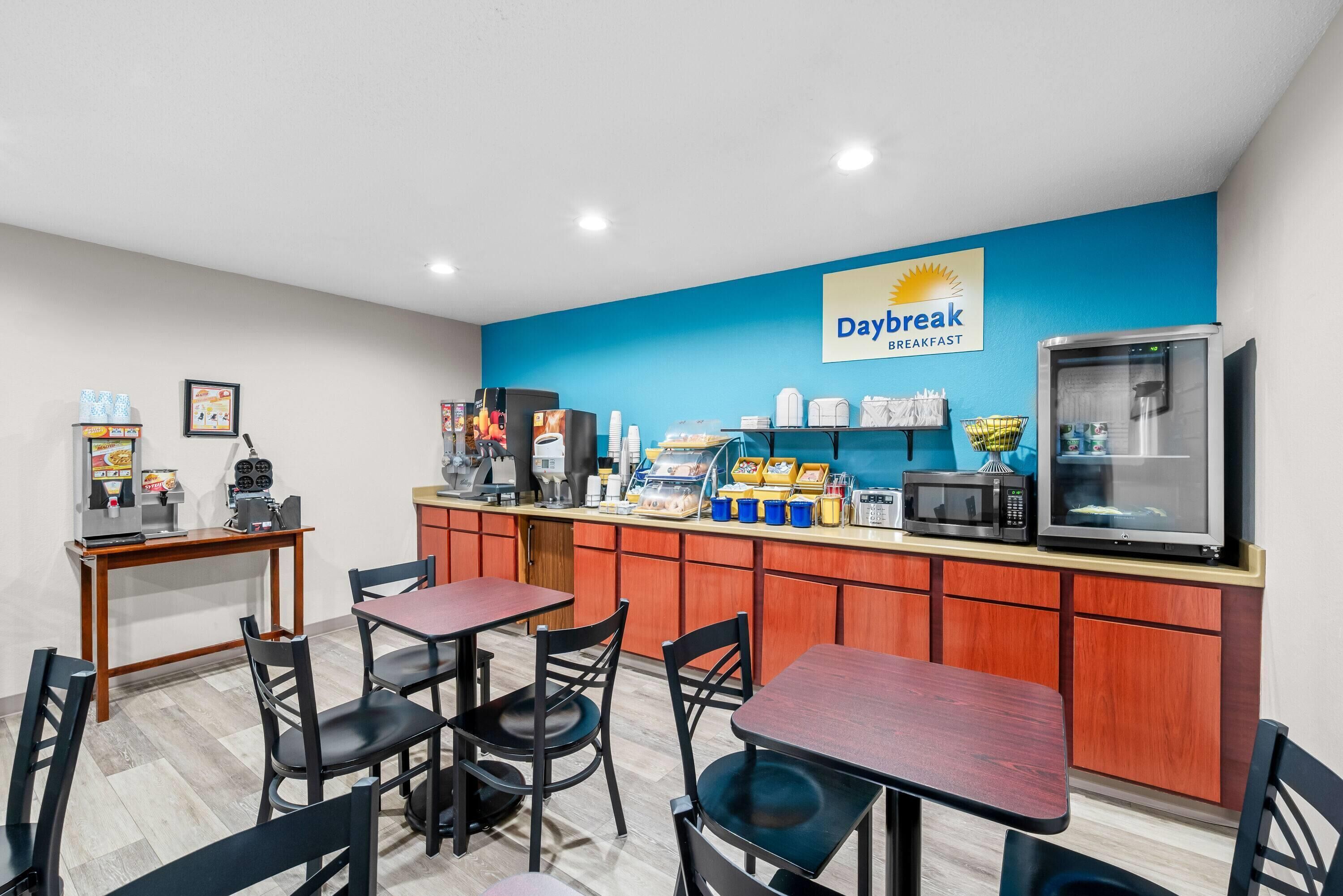 Un área de desayuno con mostrador, cafeteras y asientos.